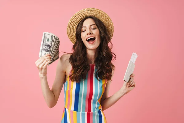 Positivo feliz joven linda mujer posando aislado sobre fondo de pared rosa celebración de pasaporte con entradas . — Foto de Stock