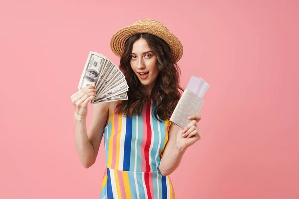 Positiva joven linda mujer posando aislado sobre fondo de pared rosa celebración de pasaporte con entradas . — Foto de Stock