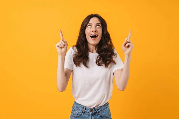 Emocional feliz surpreso jovem mulher posando isolado sobre amarelo parede fundo apontando . — Fotografia de Stock