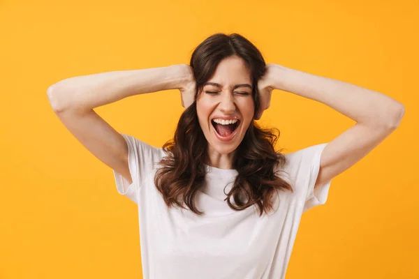 Emotionale schreiende junge Frau posiert isoliert über gelbem Wandhintergrund. — Stockfoto