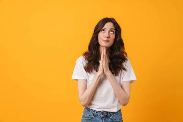 Soñar mujer joven posando aislado sobre fondo amarillo de la pared hacer rezar por favor gesto mirando a un lado . —  Fotos de Stock