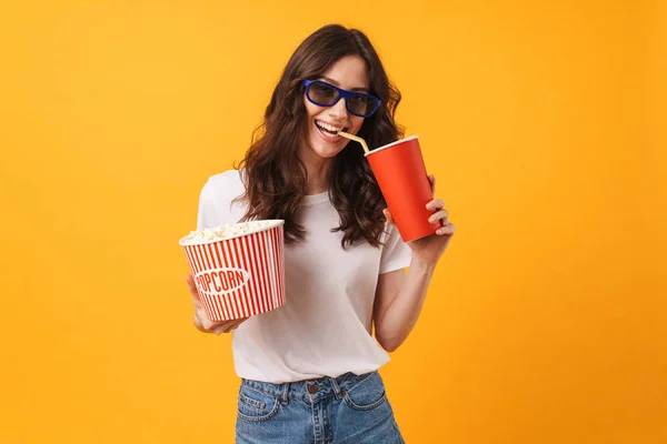 Glücklich fröhlich lächelnde junge Frau posiert isoliert über gelben Wand Hintergrund essen Popcorn Film ansehen. — Stockfoto