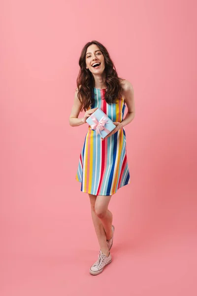 Bastante alegre sonriente positiva linda mujer posando aislado sobre fondo de pared rosa celebración regalo caja . — Foto de Stock