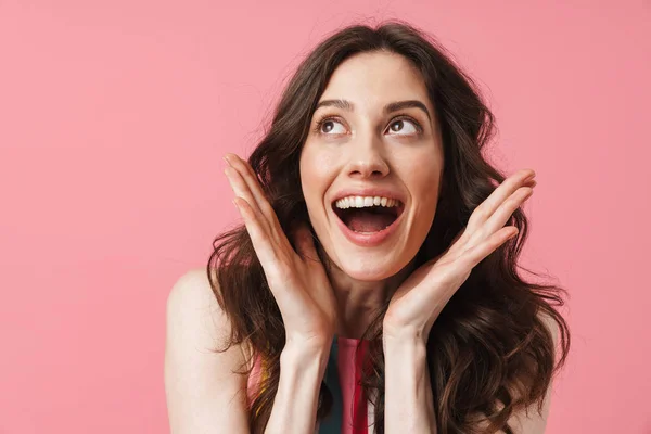 Sonriendo sorprendida mujer linda positiva posando aislada sobre fondo de pared rosa . — Foto de Stock