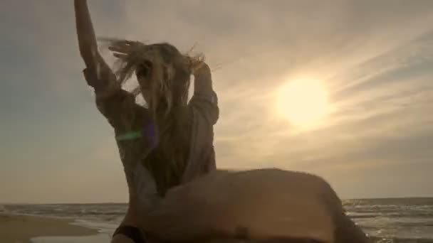 해변에 머무는 동안나부끼는 머리를 미풍을 즐기는 매력적 여자의 뒷모습 — 비디오