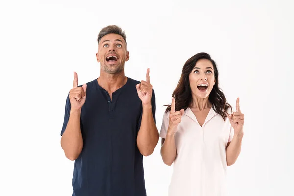 Emotional adult loving couple pointing isolated over white wall background. — Stock Photo, Image