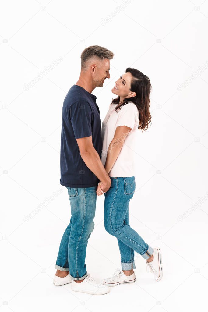 Cheerful happy adult loving couple isolated over white wall background.