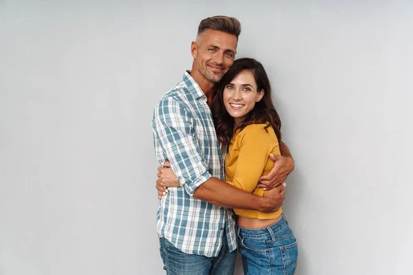 Fröhlich glücklich erwachsene liebende Paar isoliert über graue Wand Hintergrund. — Stockfoto