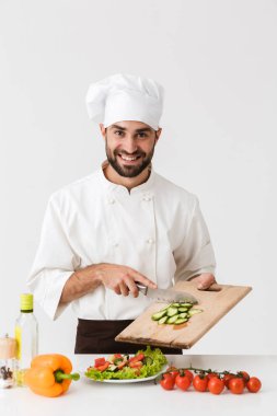 Üniformalı yakışıklı aşçının resmi gülümseyen ve vejetaryen kesen