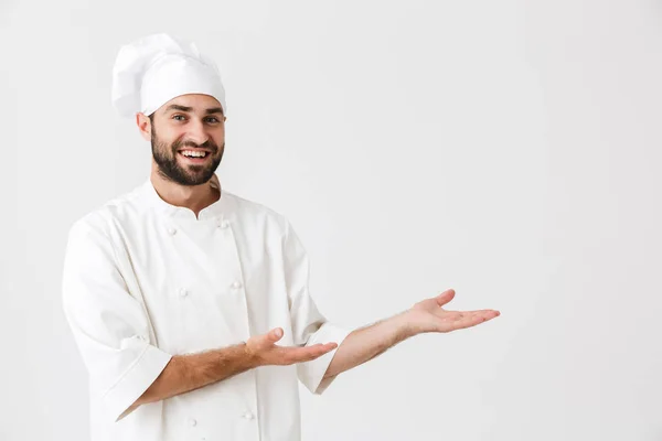 Immagine di felice capo uomo in uniforme cuoco sorridente mentre tiene c — Foto Stock