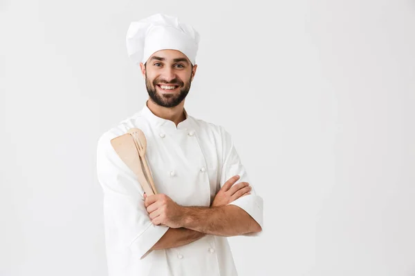Elinde tutarken gülümseyen aşçı üniformalı neşeli şef resmi — Stok fotoğraf