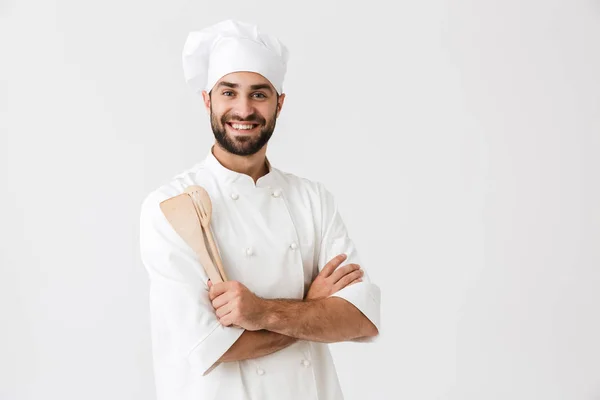 Image du chef joyeux en uniforme de cuisinier souriant tout en tenant — Photo