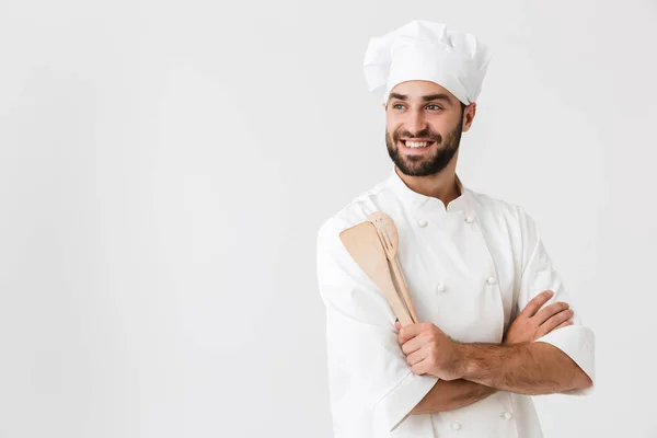 Imagem de homem chefe bonito no uniforme cozinheiro sorrindo enquanto segurando — Fotografia de Stock