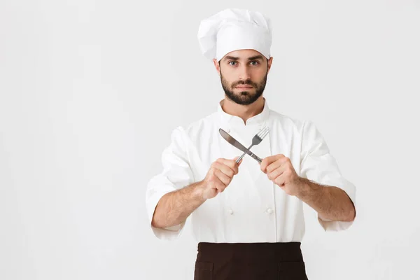 Imagem de homem chefe sério em uniforme de cozinheiro olhando para câmera whi — Fotografia de Stock