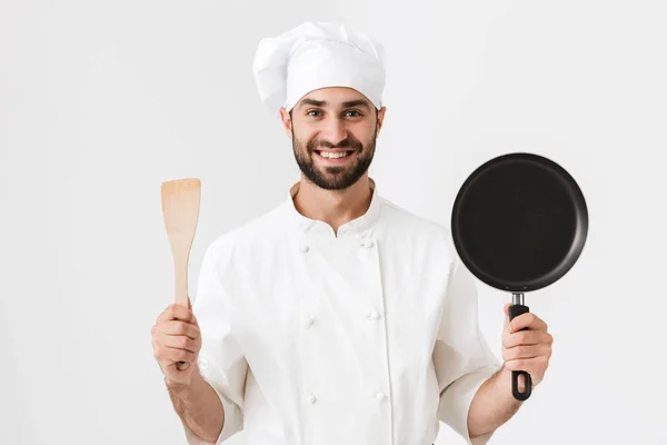 Afbeelding van gelukkige chief man in kok uniform met houten keuken — Stockfoto