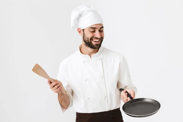 Afbeelding van vrolijke chief man in kok uniform met houten keuken — Stockfoto