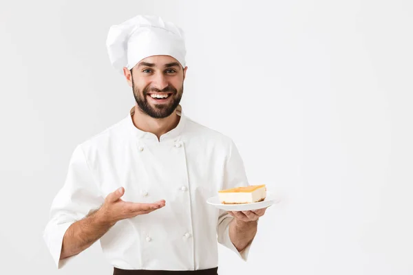 Образ положительного главного человека в форме повара улыбается и держит — стоковое фото