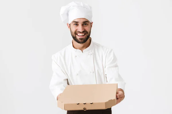 Imagen de panadero alegre hombre en uniforme de cocinero sonriendo y sosteniendo pi — Foto de Stock