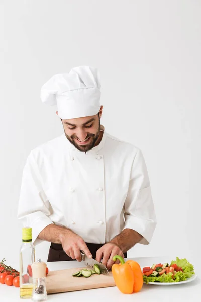Kép vidám főnök egyenruhás mosolygós és főzés vegetab — Stock Fotó
