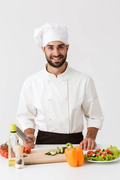 Bild av professionell chef man i uniform leende och matlagning v — Stockfoto