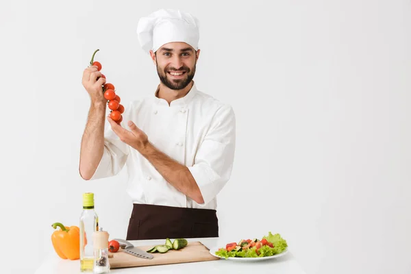 Bild av kaukasisk hövding i uniform innehav tomater medan c — Stockfoto