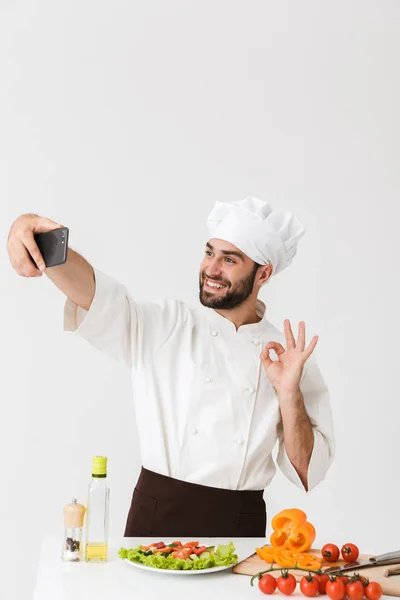 Imagen del cocinero caucásico en uniforme mostrando signo de ok y takin —  Fotos de Stock