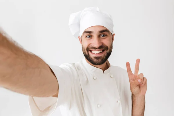 Imagem do chef caucasiano homem em chapéu de cozinheiro mostrando sinal de paz e s — Fotografia de Stock