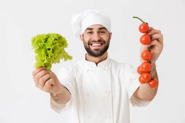 Image of handsome chef man in cook hat smiling while holding tom — Stock Photo, Image