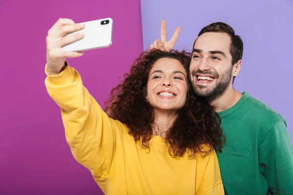 Retrato de pareja caucásica divertida en ropa de colores que tiene f — Foto de Stock