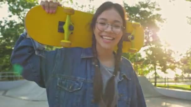 Bella Ragazza Bruna Giacca Jeans Sorridente Tenendo Skateboard Sulle Spalle — Video Stock