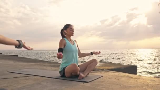 Spor Kıyafetleri Içinde Yoga Yapan Deniz Kenarındaki Minderlerde Otururken Ele — Stok video