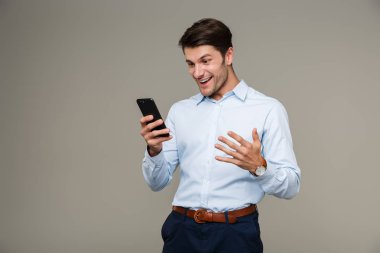 Kol saati takan, gülümseyen ve cep telefonu kullanan mutlu bir adam resmi.