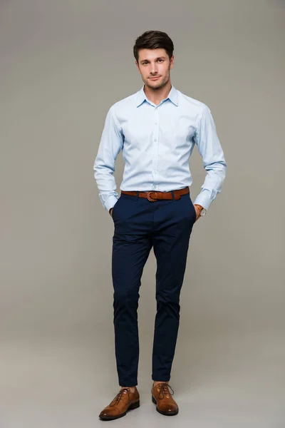 Image of confident young man wearing shirt standing with hands in pockets — Stock Photo, Image