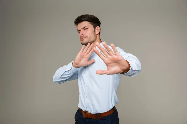 Image d'un jeune homme perplexe portant des vêtements formels montrant un geste d'arrêt à la caméra — Photo