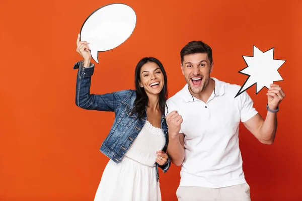 Optimistisch emotional positiv glücklich liebendes Paar isoliert über roter Wand Hintergrund hält Sprechblasen. — Stockfoto