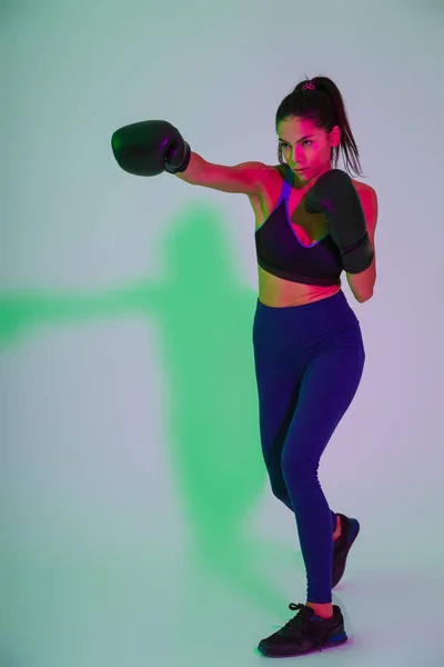 Mulher de fitness forte bonito boxer isolado com luzes de flash led fazer exercícios de boxe . — Fotografia de Stock