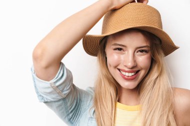 Mutlu gülümseyen, iyimser, şapkalı, beyaz duvar arkasında izole edilmiş güzel bir kadın..