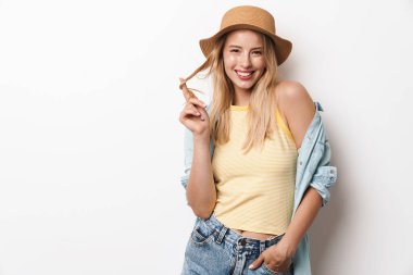 Mutlu gülümseyen, iyimser, şapkalı, beyaz duvar arkasında izole edilmiş güzel bir kadın..