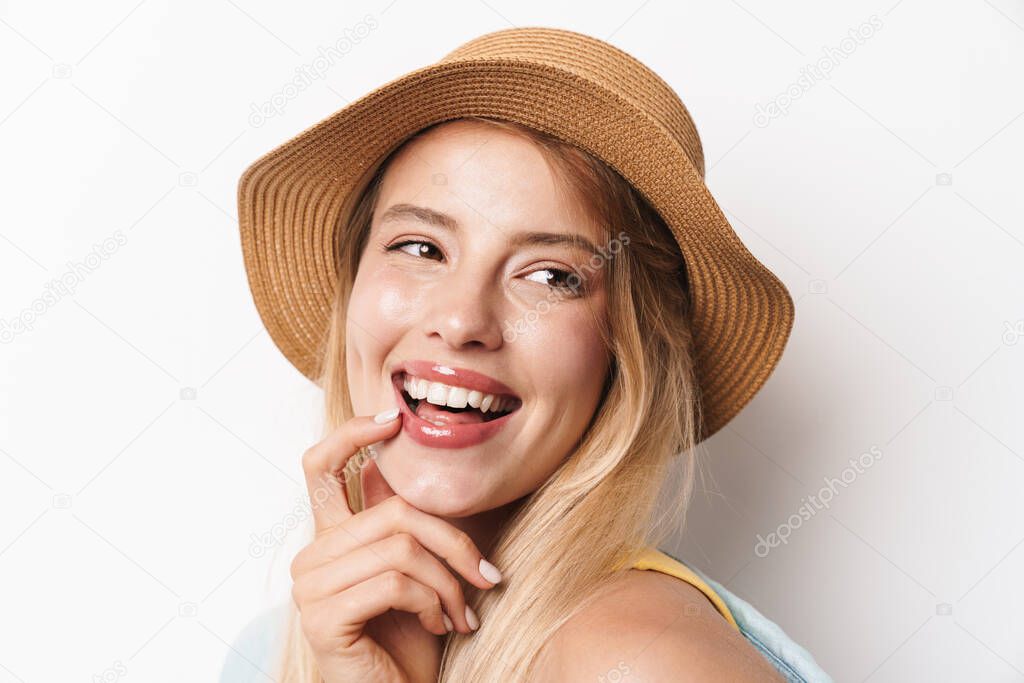 Happy smiling optimistic young pretty woman wearing hat posing isolated over white wall background.