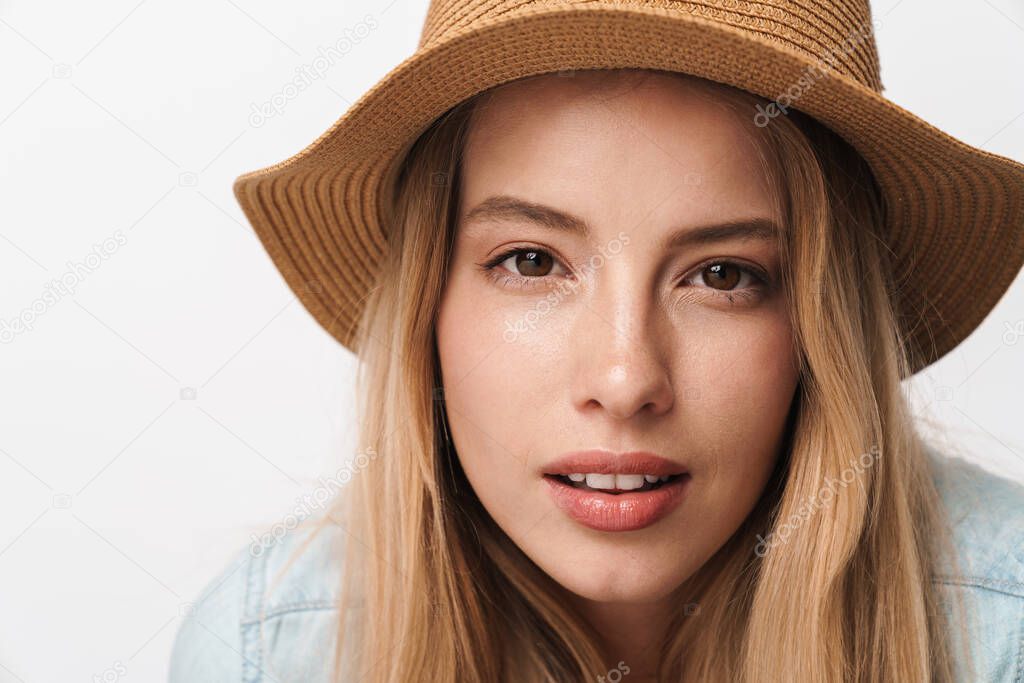 Serious amazing young pretty woman wearing hat posing isolated over white wall background.