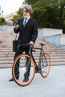 Yakışıklı, kendine güvenen, sakallı, takım elbiseli adam.