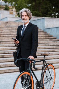 Yakışıklı, kendine güvenen, sakallı, takım elbiseli adam.