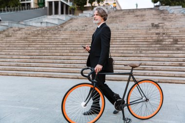 Yakışıklı, kendine güvenen, sakallı, takım elbiseli adam.