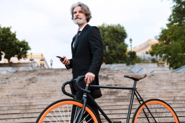 Yakışıklı, kendine güvenen, sakallı, takım elbiseli adam.