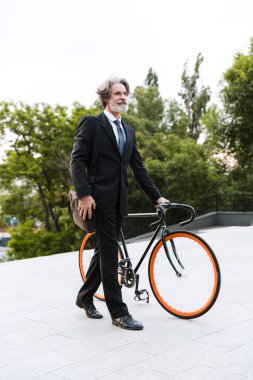 Yakışıklı, kendine güvenen, sakallı, takım elbiseli adam.