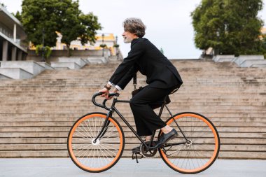 Yakışıklı, kendine güvenen, sakallı, takım elbiseli adam.