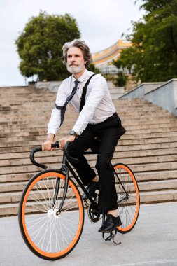 Yakışıklı, kendine güvenen, sakallı, takım elbiseli adam.