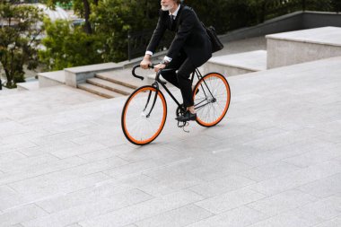 Yakışıklı, kendine güvenen, sakallı, takım elbiseli adam.