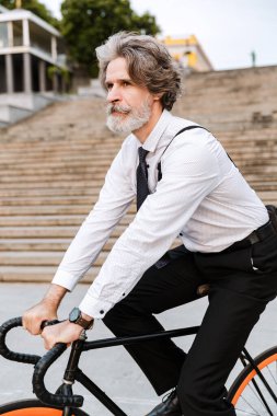 Yakışıklı, kendine güvenen, sakallı, takım elbiseli adam.