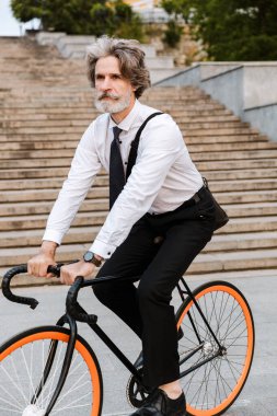 Yakışıklı, kendine güvenen, sakallı, takım elbiseli adam.